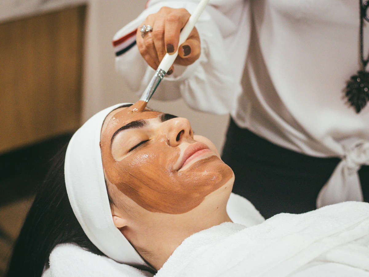 A face mask being brushed on during a facial
